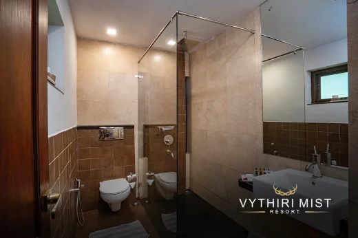 Spacious bathroom with separate shower area and luxurious furnishings at Vythiri Mist Resort