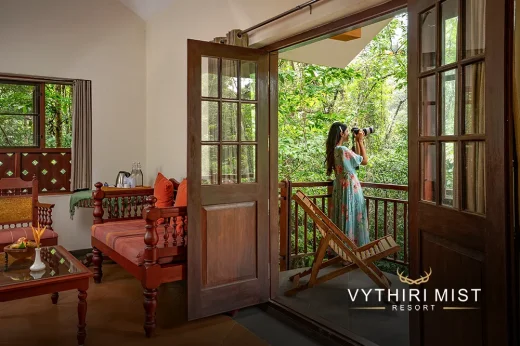 She is enjoying the scenery of lush greenery in the Vythiri Mist Resort